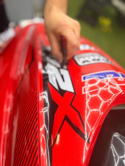 Instalación de kit de vinilos personalizados en moto de agua Sea-Doo roja